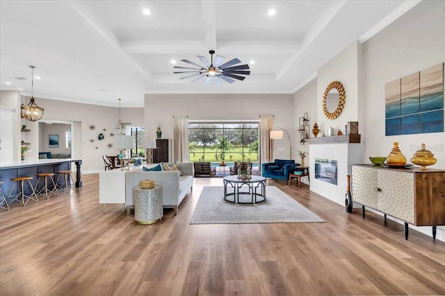 living room featuring ceiling fan, hardwood / wood-style flooring, and beam ceiling