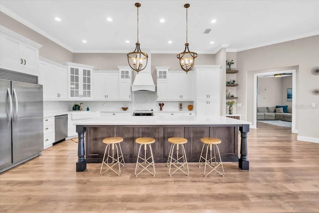 kitchen featuring appliances with stainless steel finishes, a kitchen island, a kitchen breakfast bar, and white cabinets