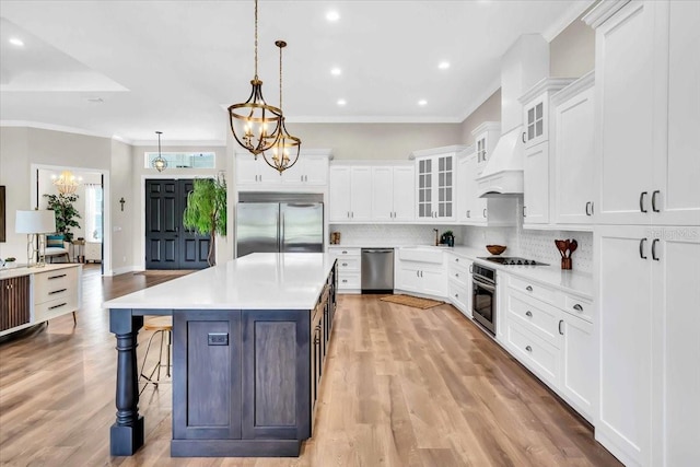 kitchen featuring hanging light fixtures, white cabinetry, and stainless steel appliances