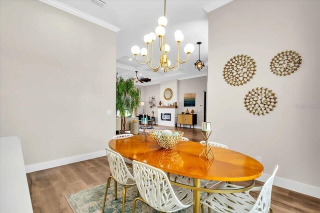 dining space with wood-type flooring, a notable chandelier, and ornamental molding