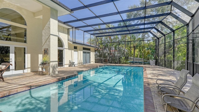 view of swimming pool with a patio and glass enclosure