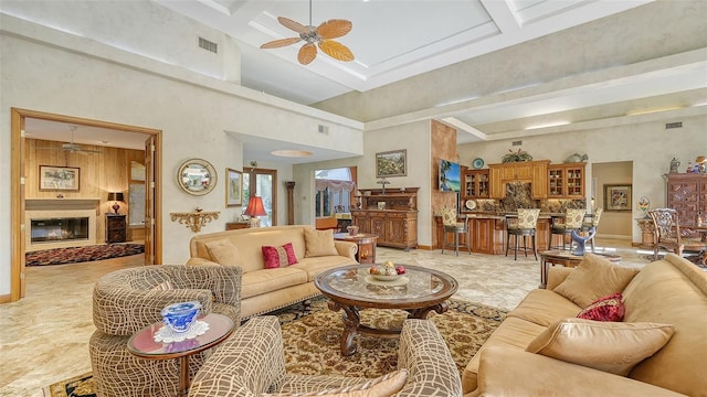 living room with coffered ceiling, beam ceiling, a towering ceiling, and ceiling fan