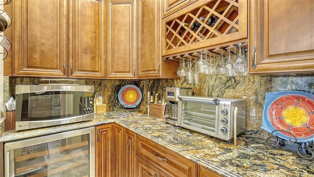 kitchen featuring beverage cooler, backsplash, and stone countertops