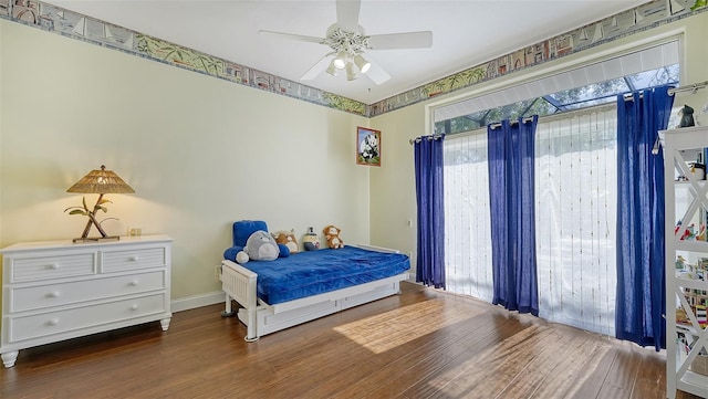 bedroom with multiple windows, dark hardwood / wood-style floors, and ceiling fan