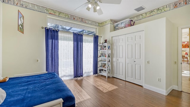 bedroom featuring wood-type flooring, ceiling fan, and a closet