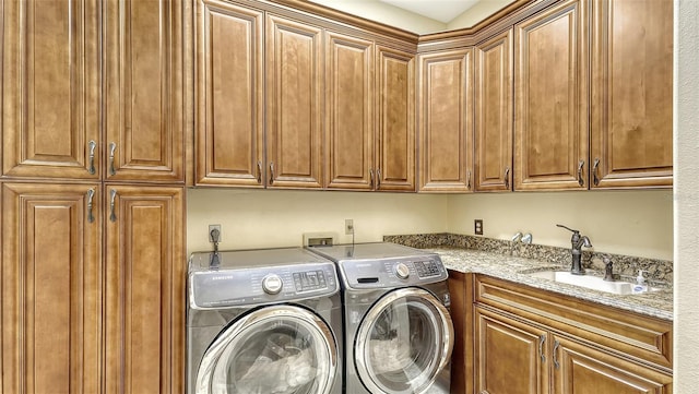 laundry area with separate washer and dryer, cabinets, and sink