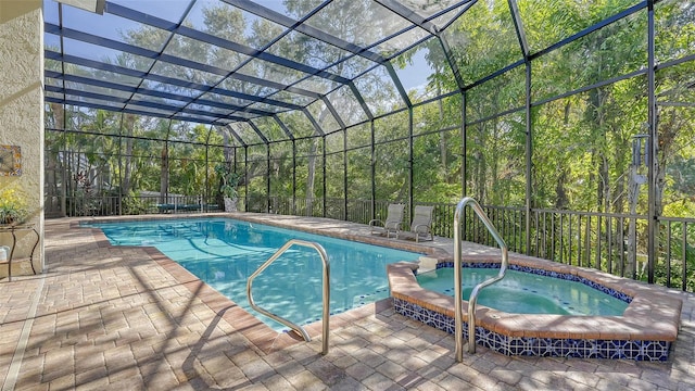 view of swimming pool with a lanai, an in ground hot tub, and a patio area