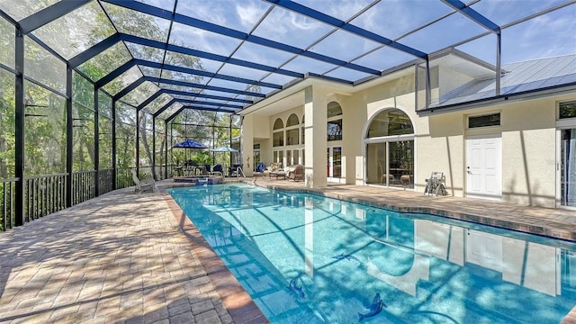 view of swimming pool with glass enclosure and a patio area