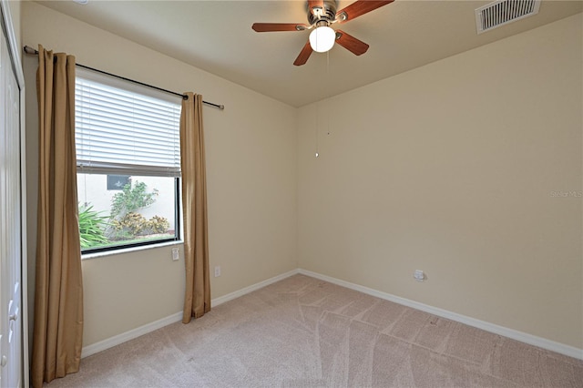 carpeted spare room featuring ceiling fan and a wealth of natural light