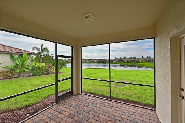 unfurnished sunroom featuring a water view