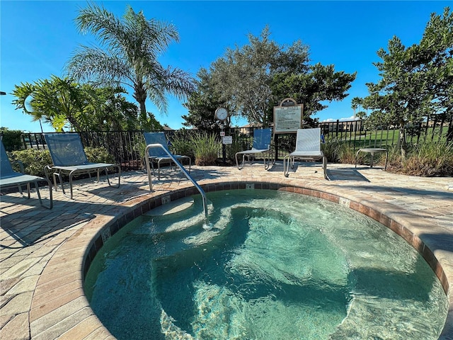 view of pool featuring a hot tub and a patio area