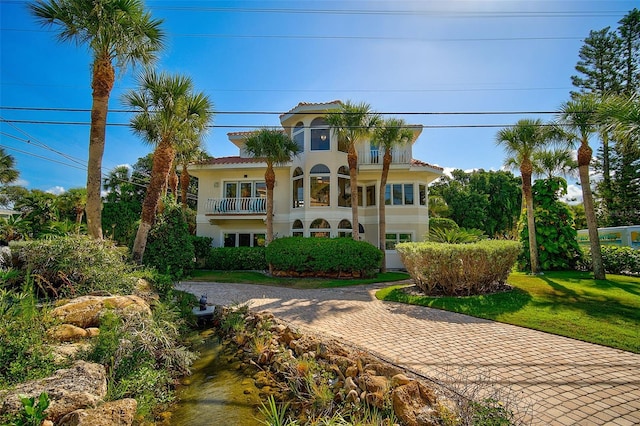 mediterranean / spanish-style home with a balcony and a front yard