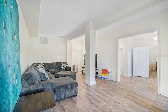 living room featuring ornamental molding and light hardwood / wood-style floors