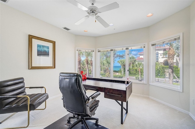 carpeted office space with ceiling fan