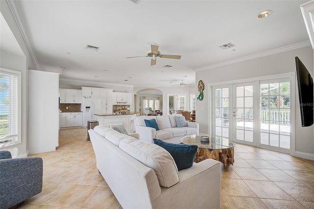 living room with light tile patterned floors, ornamental molding, ceiling fan, and french doors