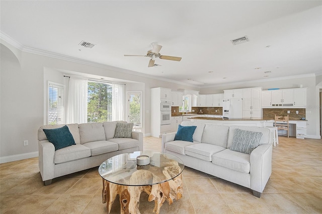 living room featuring crown molding, light tile patterned floors, and ceiling fan