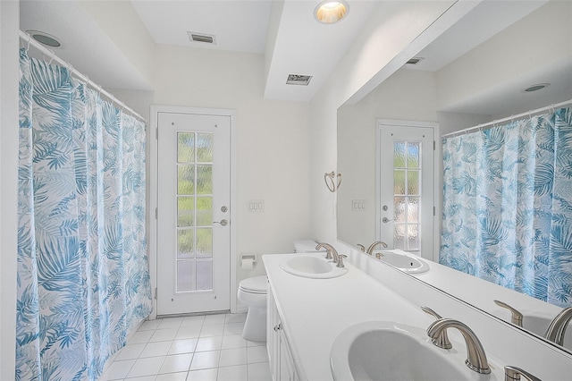 bathroom featuring tile patterned flooring, vanity, toilet, and plenty of natural light