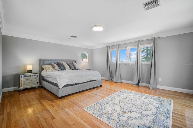 bedroom with light hardwood / wood-style flooring and crown molding