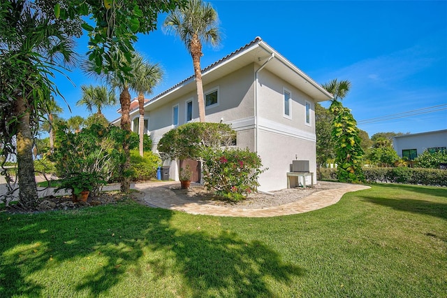 view of side of home featuring a yard and central AC