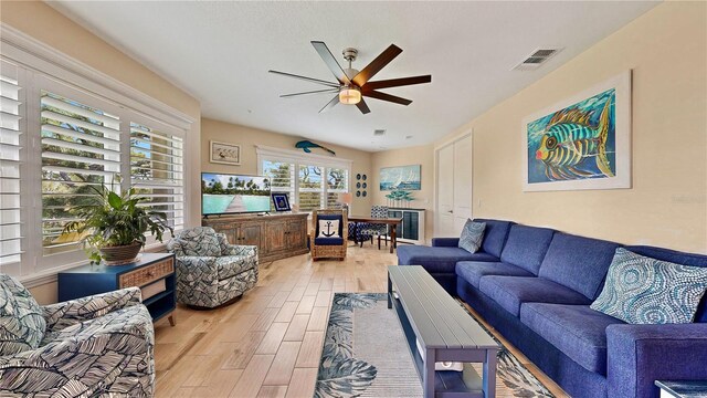 living room featuring ceiling fan and light wood-type flooring