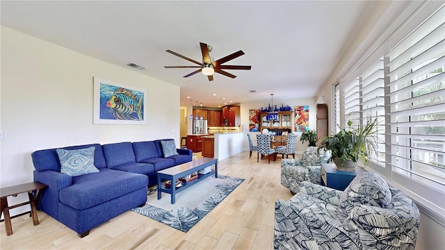 living room with light hardwood / wood-style floors and ceiling fan