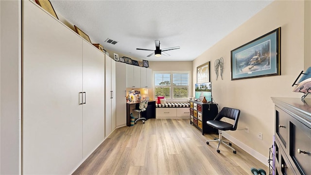 office area featuring light hardwood / wood-style floors, ceiling fan, and a textured ceiling