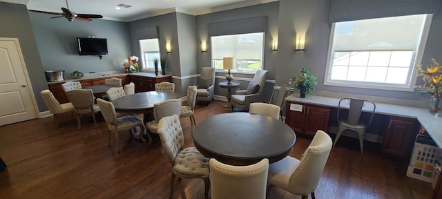 dining area with ceiling fan, ornamental molding, and dark wood-type flooring