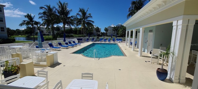 view of pool with a water view and a patio area