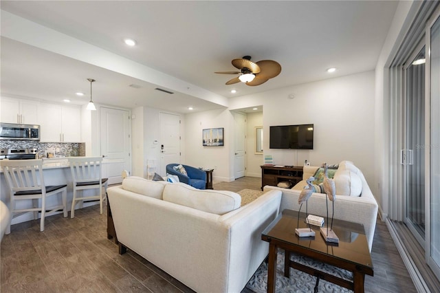 living room featuring dark hardwood / wood-style flooring and ceiling fan