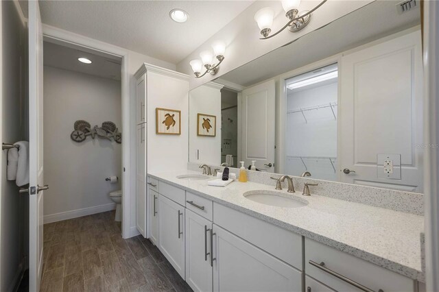 bathroom featuring wood-type flooring, vanity, and toilet