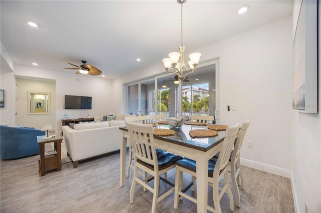 dining room with ceiling fan with notable chandelier and light hardwood / wood-style flooring