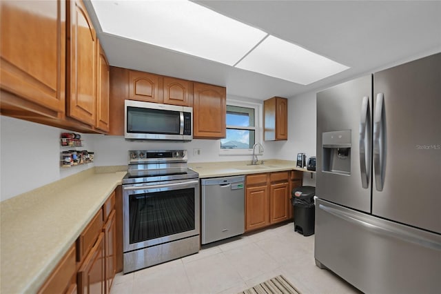 kitchen featuring light tile patterned floors, sink, and stainless steel appliances