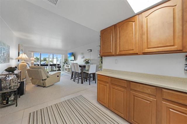 kitchen with vaulted ceiling and light tile patterned floors