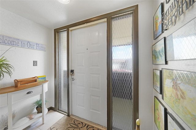 tiled entryway with a textured ceiling