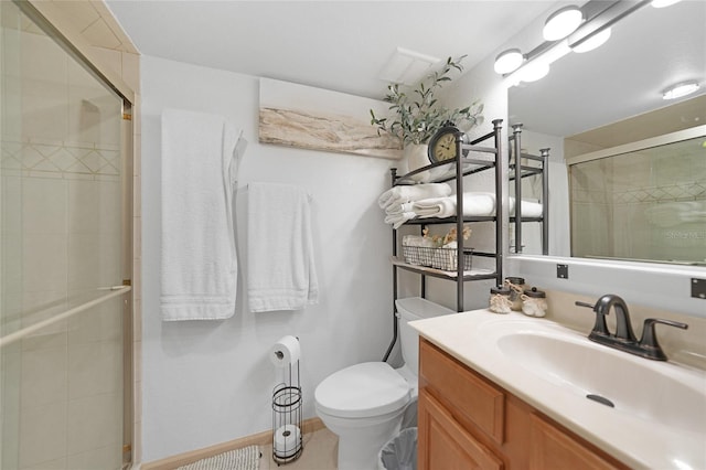 bathroom with a shower with door, vanity, and toilet