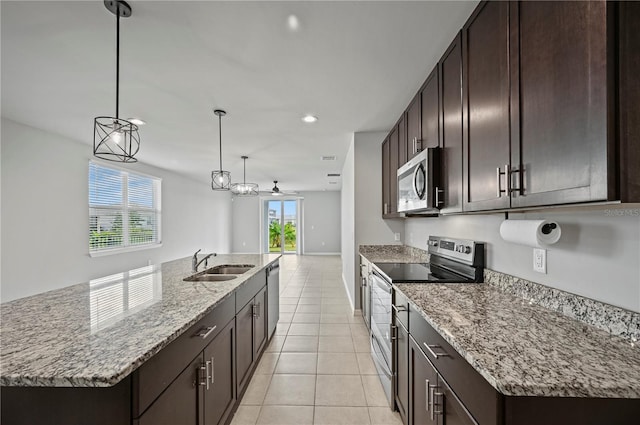 kitchen with hanging light fixtures, a center island with sink, sink, and stainless steel appliances