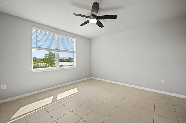 tiled spare room featuring ceiling fan