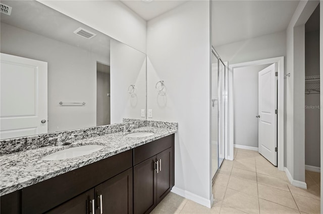 bathroom with vanity, a shower with shower door, and tile patterned floors