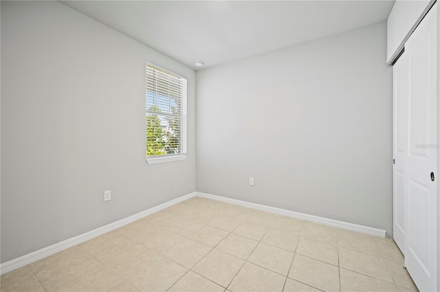 unfurnished bedroom featuring light tile patterned flooring and a closet