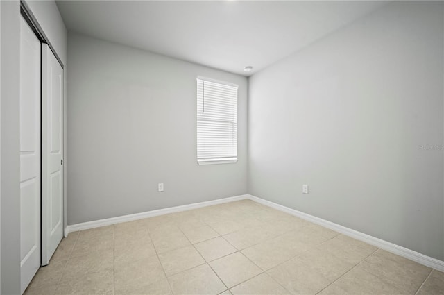 unfurnished bedroom featuring a closet and light tile patterned flooring