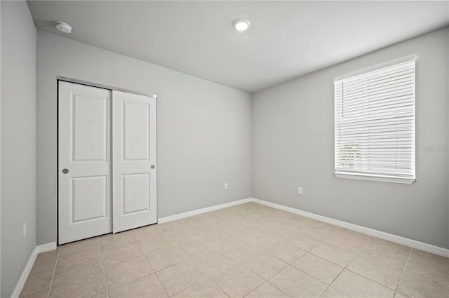 unfurnished bedroom with a closet and light tile patterned flooring