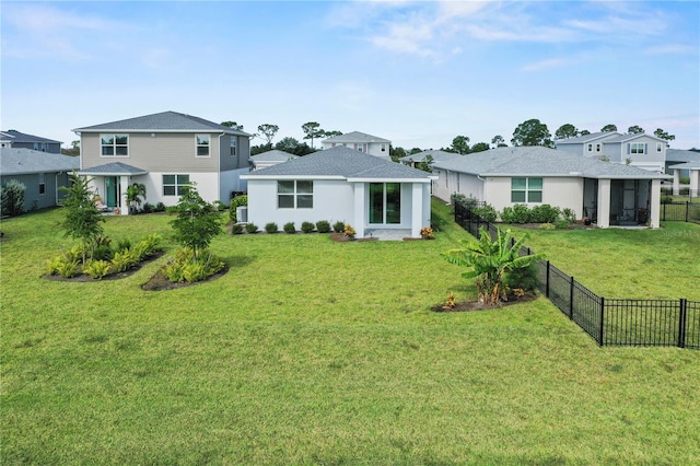 rear view of property featuring a lawn