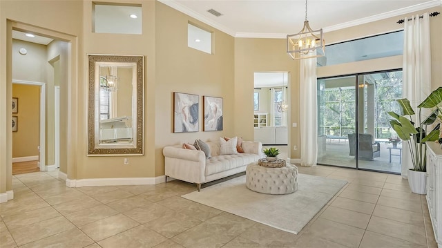 living room featuring ornamental molding, a towering ceiling, a notable chandelier, and light tile patterned floors