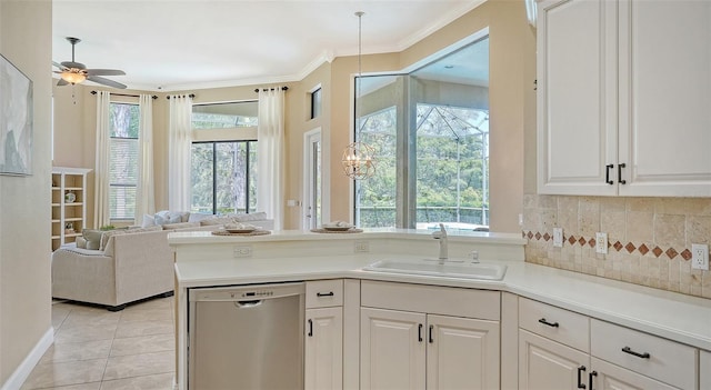 kitchen featuring stainless steel dishwasher, a wealth of natural light, sink, and white cabinets