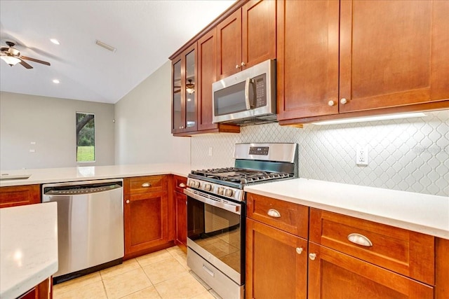 kitchen featuring ceiling fan, light tile patterned floors, tasteful backsplash, appliances with stainless steel finishes, and vaulted ceiling