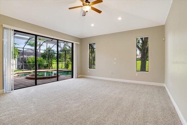 carpeted spare room with lofted ceiling, ceiling fan, and a wealth of natural light