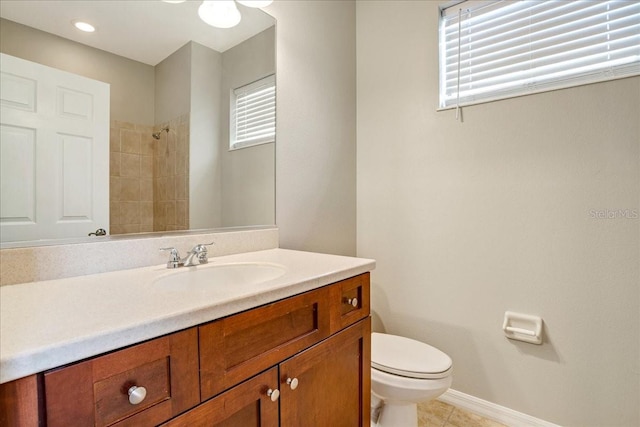 bathroom with tiled shower, vanity, toilet, and tile patterned flooring