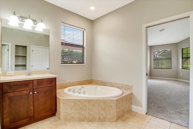 bathroom featuring tiled tub, vanity, tile patterned floors, and plenty of natural light