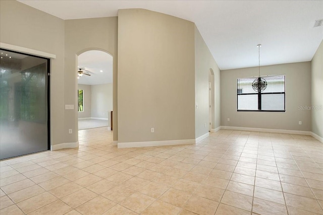 spare room featuring a wealth of natural light, lofted ceiling, ceiling fan, and light tile patterned flooring