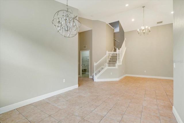 spare room with an inviting chandelier and light tile patterned floors